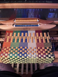 a loom with a colorful woven pattern on it