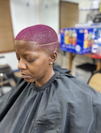 a woman with a pink shaved hair in a barber shop