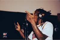 a man with dreadlocks is holding a microphone