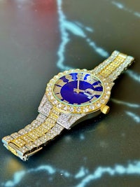 a gold and blue watch with diamonds on it