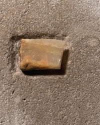 a small piece of stone is sitting on a concrete floor