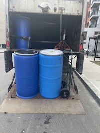 two blue barrels sitting in the back of a truck