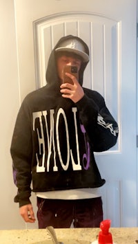 a man in a black hoodie taking a selfie