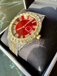 a red and gold watch in a box