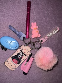 a pink keychain with a pink pom pom on it