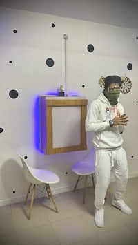 a man wearing a mask standing in front of a polka dot wall