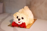 a cake shaped like a dog with a red bow tie
