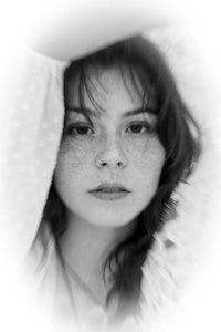 a black and white photo of a woman with freckles
