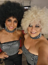two women with afro wigs posing for a photo