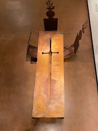 a sculpture of a cross on a table in a museum