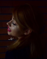 a woman in a dark room with lipstick on her lips