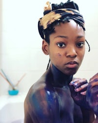 a young woman in a bath with paint on her face