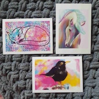 three cards with a cat, a bird and a unicorn