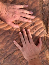 two hands reaching into a rock formation
