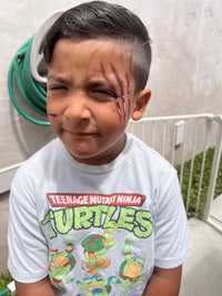 a young boy with a teenage mutant ninja turtle on his face