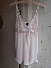a pink lace top hanging on a hanger