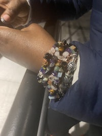 a person wearing a bracelet with a lot of stones on it