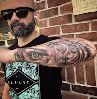 a man with a tiger tattoo on his arm