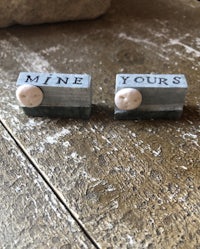 two wooden cufflinks with the words mine yours on them