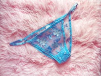 a blue thong laying on a pink fur rug