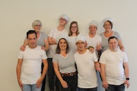 a group of people in white t - shirts posing for a picture