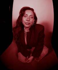a woman posing in front of a red background