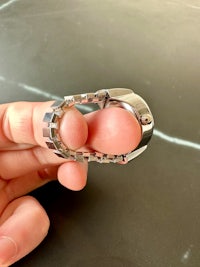 a person's finger holding a silver ring