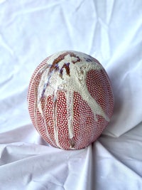 a red and white ball on a white cloth