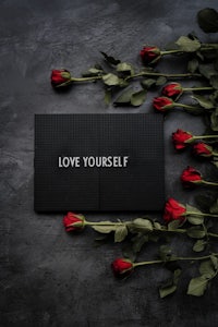 a black book with red roses and the word love yourself