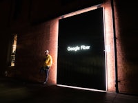 a man standing in front of a building with a sign that says google fiber