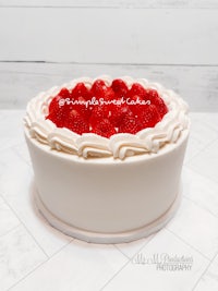 a white cake topped with strawberries and whipped cream