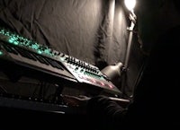 a man playing an electronic keyboard in a dark room