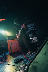 a man playing guitar on stage in a dark room