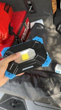 a person holding a flashlight in the back of a car