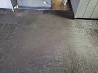 a kitchen floor with a black tiled floor