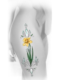 a woman's thigh with a yellow daffodil tattoo