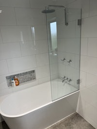 a bathroom with a glass shower enclosure