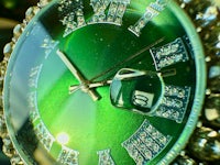 a green watch with diamonds on it