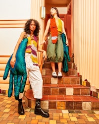 two women standing on stairs with giant handbags