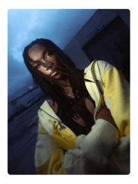 a woman with dreadlocks in a yellow jacket
