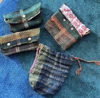 three tweed pouches on a blue rug