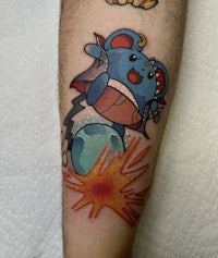a tattoo of a pokemon on a person's forearm