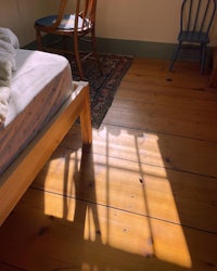 a wooden floor in a room with a bed and a chair