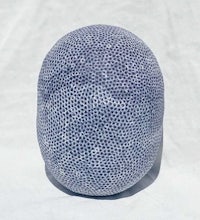 a blue and white ceramic ball sitting on top of a white surface