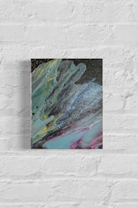 an abstract painting hanging on a brick wall