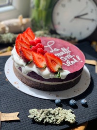 a cake with berries and a clock on it