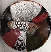 a plate with a red, brown, and black design