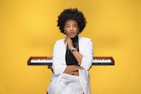 a woman with afro hair sitting in front of a keyboard