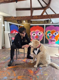 a man petting a dog in an art studio