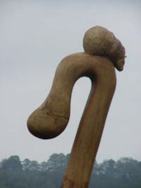 a wooden sculpture with a head on top of it